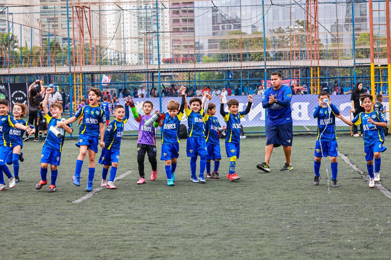 Alunos da Olímpia comemorando em campo com o professor